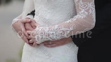 新娘手里拿着结婚花束，新郎从后面拥抱她。 新郎从背后拥抱新娘
